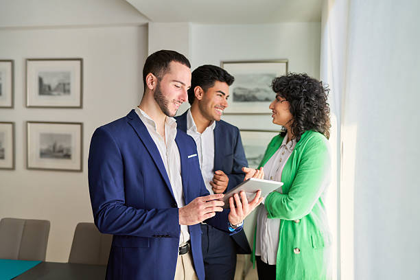 istock Real estate agents showing property information on tablet to client 2203764647