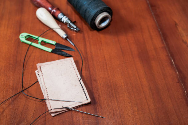 Leather crafting tools for hand stitching on wooden table, Leather and the craft tools.