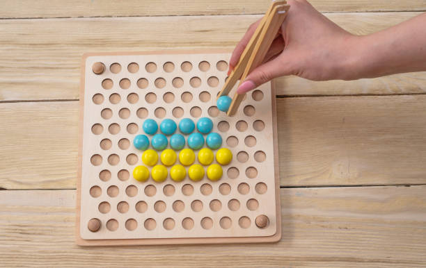 istock The game develops fine motor skills, logical thinking according to the Montessori system. 2203768023