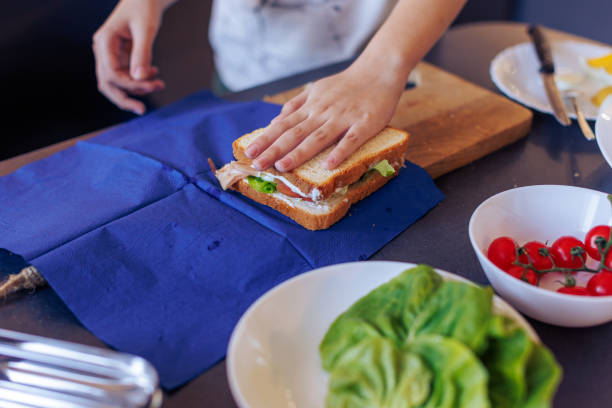 istock 10-Year-Old Boy Making a Sandwich and Packing school Lunch in a Home Kitchen 2203768822