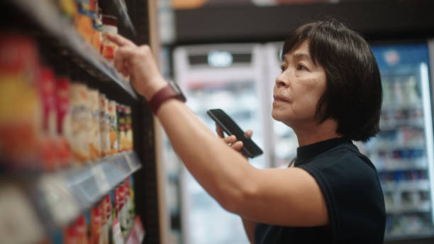 istock Mature woman talking with chatbot while shopping at mart. 2203769629