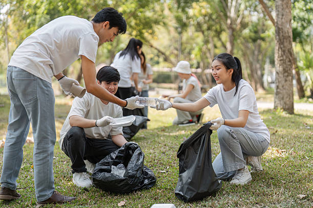 istock Volunteers exchanging materials during a park cleanup, emphasizing teamwork and environmental stewardship. 2203771290
