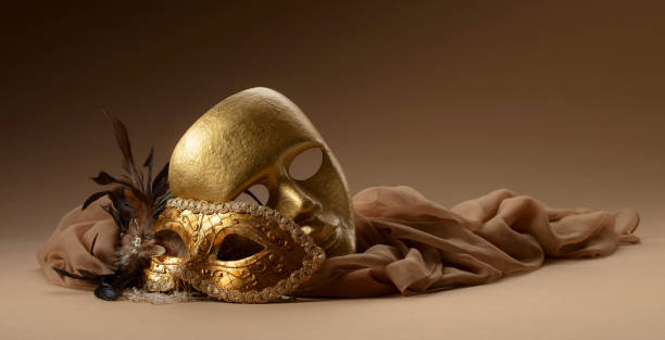 istock Golden Venetian carnival masks on a beige background. 2203772387