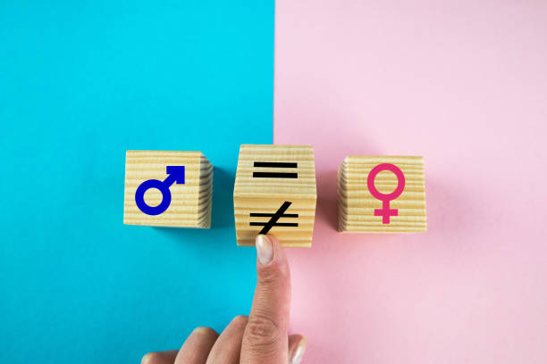 istock Gender equality symbol. Hand turns cube and changes inequality sign to equal sign between male and female symbols. Nice pink and blue background, copy space 2203772876