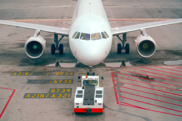 istock The tow tractor pushes the plane for towing and engine start, front view 2203774432