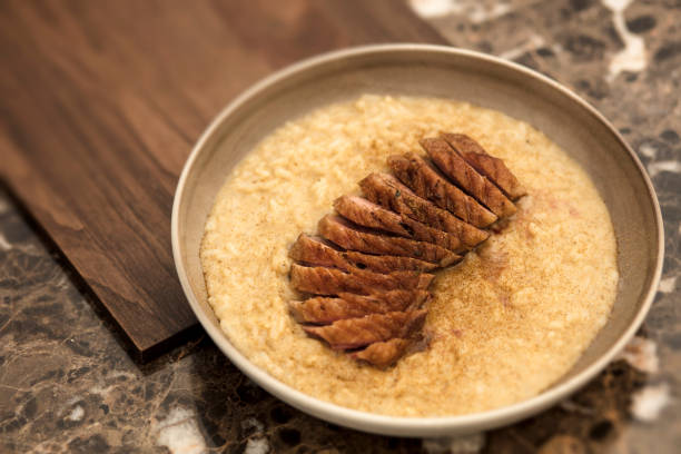 A flavorful plate of chicken curry served with rice, pineapple garnish, and fresh garnishments on a wooden table. The dish is presented beautifully, making it perfect for culinary and food-related themes