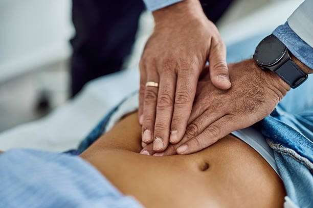 istock Medical Professional Performing Abdominal Examination on a Patient in Clinic Setting 2203780572
