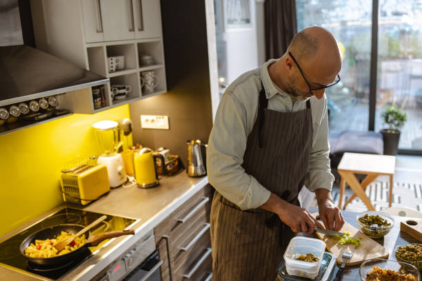 istock Mature man preparing food at home 2203781489