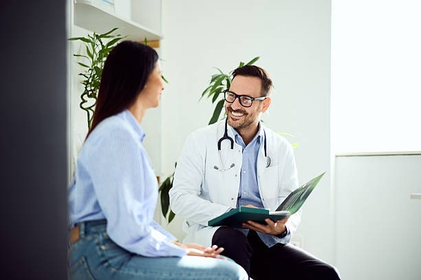 istock Doctor Consulting Smiling Patient in Modern Office Setting 2203782693