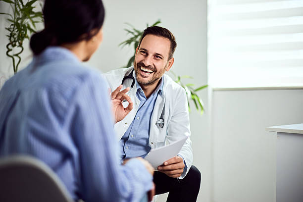 istock Smiling Doctor Discussing With Patient Inside a Modern Medical Office 2203782696