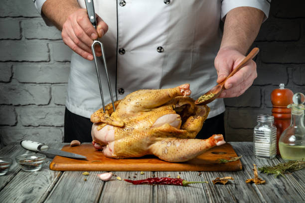 istock Inside a rustic kitchen, a skilled chef meticulously seasons and carves a perfectly roasted chicken. Fresh herbs and spices enhance the dish, creating an inviting atmosphere for cooking enthusiasts 2203782998
