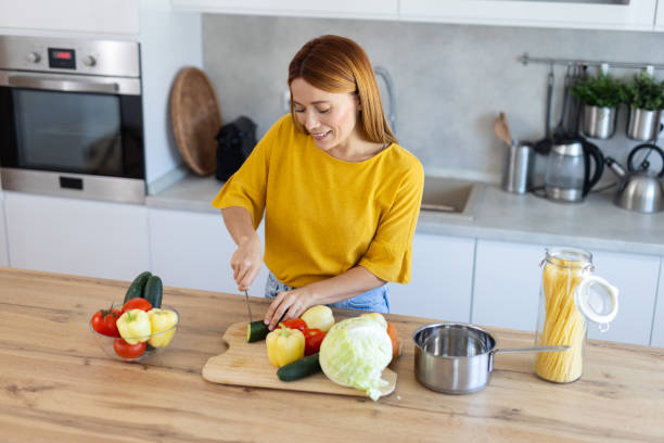 istock Happy Woman Preparing Salad with Fresh Ingredients 2203783897