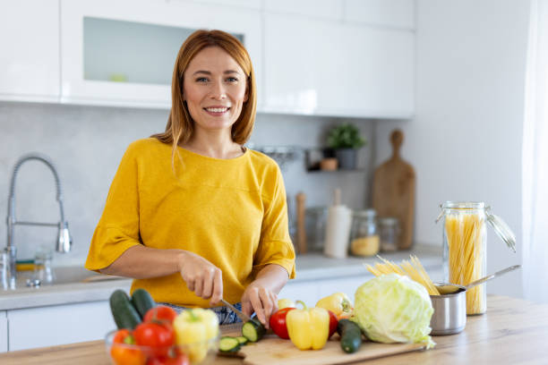 istock Charming Woman Smiling While Cooking in Modern Kitchen 2203783898