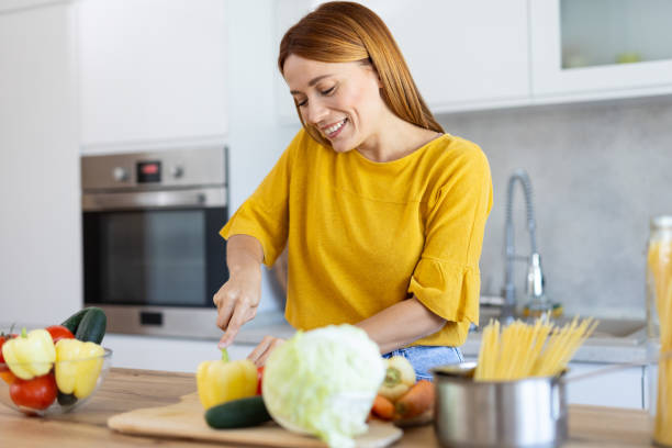 istock Smiling Woman: Joyful Cooking with Fresh Ingredients 2203783915