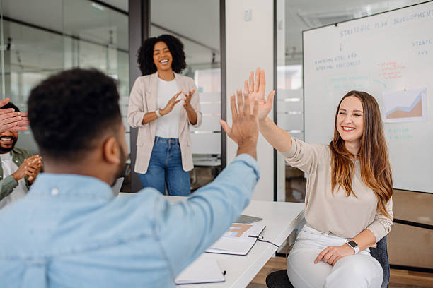istock A diverse group of professionals in a modern office celebrates success with a high-five 2203784046