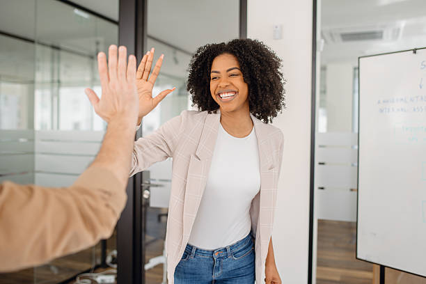 istock A diverse group of professionals in a modern office celebrates success with a high-five 2203784059