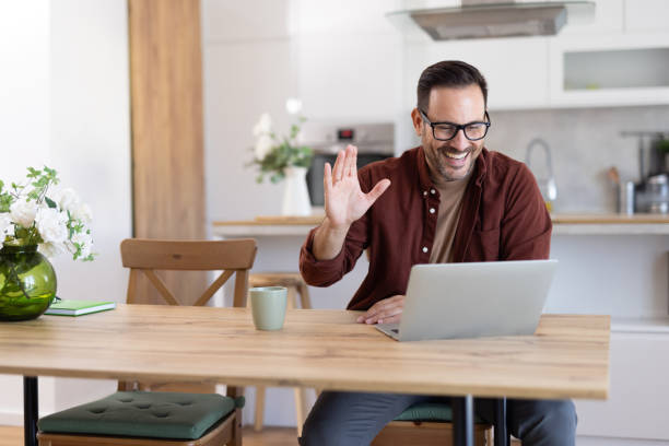 istock Man waving during lively online meeting at home office 2203784966