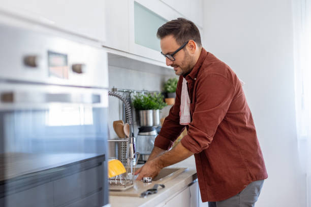 istock Focused Man Washing Dishes in Contemporary Bright Kitchen 2203785005