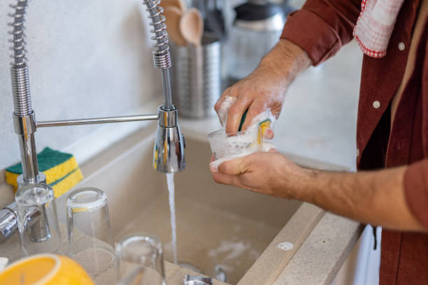 istock Man Washing Dishes with Soap and Water at Kitchen Sink 2203785011