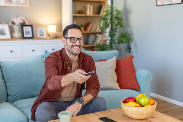 istock Content Man Watching TV with Remote, Cozy Room Vibe 2203785039