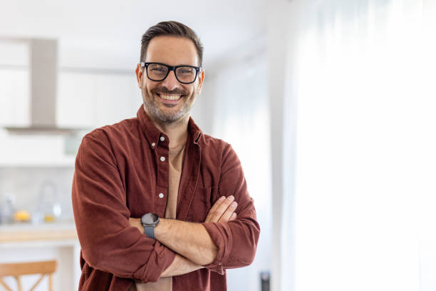 istock Smiling Man Standing with His Arms Crossed in Bright Home 2203785042