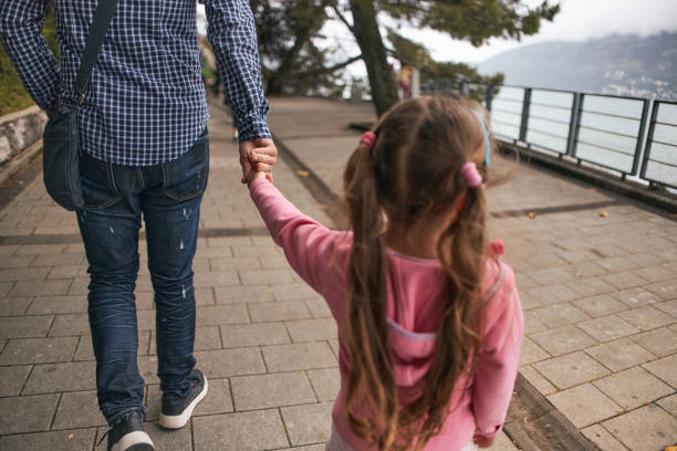 Man and child holding hands outdoors, closeup
