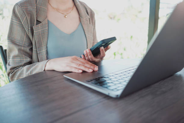 istock Close up female hands using smartphone shopping online, Freelancer remote working from coffee shop. 2203786564