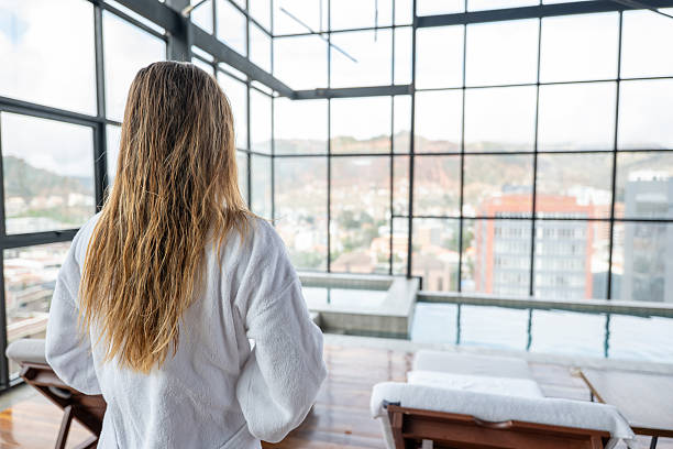 istock Woman in Spa Resort Overlooking Cityscape 2203788896