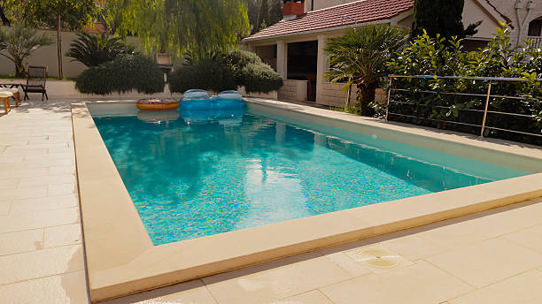 istock Luxury Rectangular Pool With Cream Pavers And Tropical Landscaping In Modern Backyard Setting 2203789492