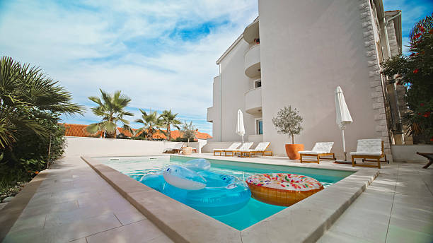 istock Private Pool with Bright Inflatable Floats and Elegant Lounge Chairs under Clear Blue Sky 2203789950