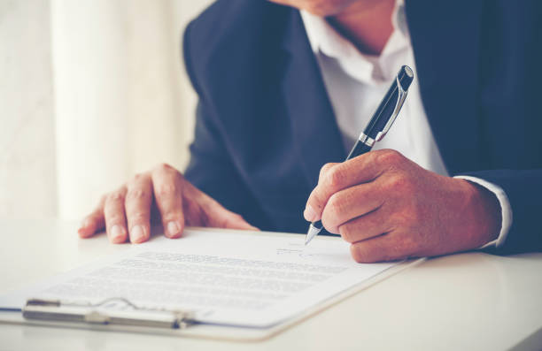 istock Businessman hand using pen signing on new contract to starting projects in conference room. Close up business manager man hands sign contract legal document in meeting room. Business agreement concept 2203790336