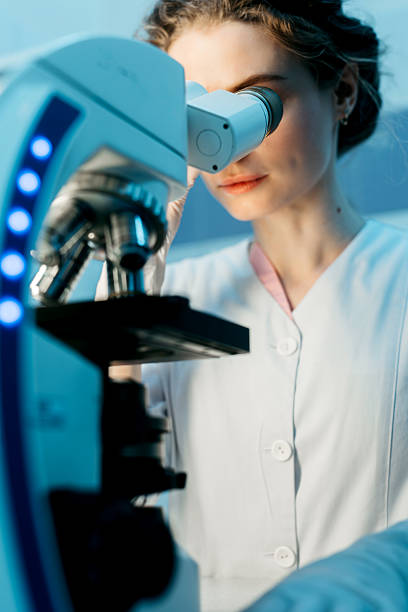 istock A young female scientist conducts research in a medical lab, using a microscope. 2203791331