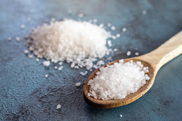 Natural salt and wooden spoon, top view stock photo