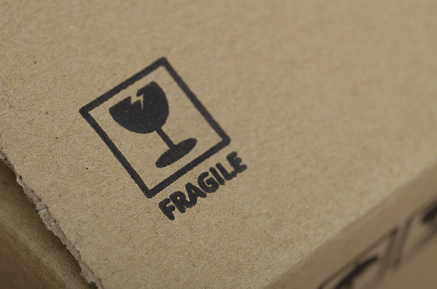 istock Warning Label FRAGILE Printed on Textured Brown Box 2203799933
