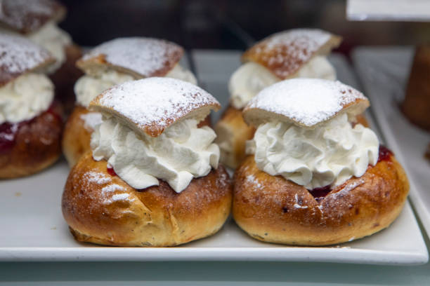 The bun is spiced with cardamom, sliced open, and filled with almond paste and whipped cream, and then topped with a dusting of powdered sugar