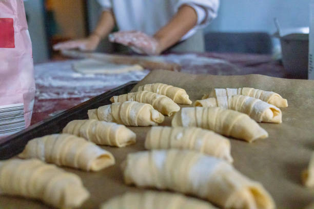 istock Close-up of dough rolls with cheese arranged in a baking pan and ready to bake 2203800469