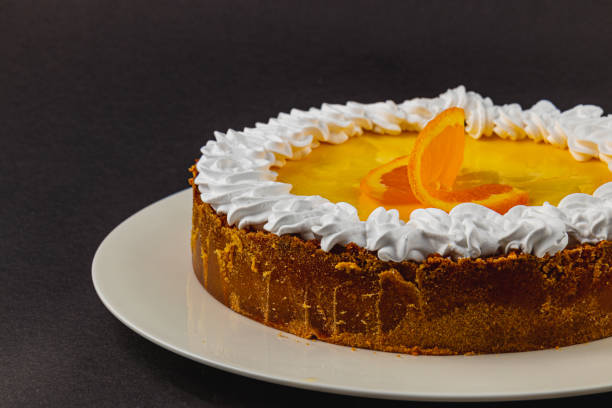 istock Bright orange dessert garnished with creamy topping on a white plate 2203801620