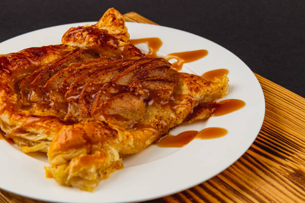 istock Flaky pastry dessert drizzled with caramel and adorned with apples 2203802599