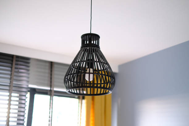 istock A black lamp with a yellow cord hanging from it. 2203803220