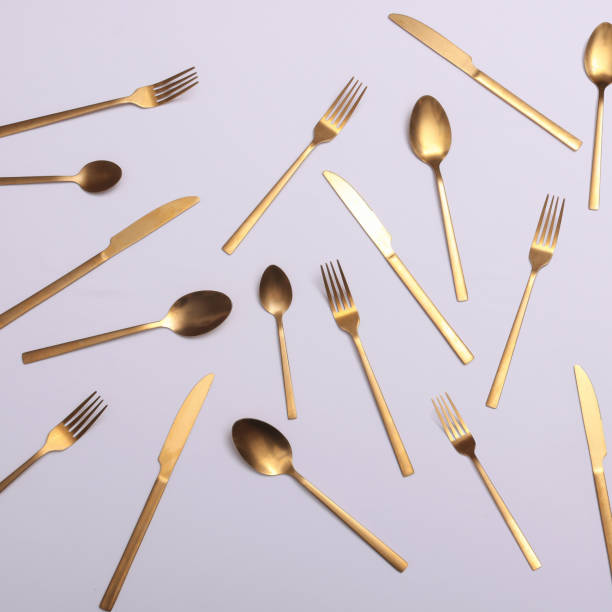 istock Gold cutlery on white shinny silk satin 2203803264