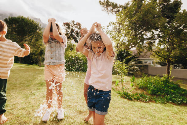 istock Children playing with water in a sunny backyard during summer 2203804168