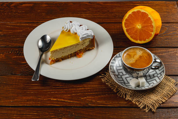 istock Enjoying a delicious slice of orange cheesecake with coffee on a rustic table 2203804424