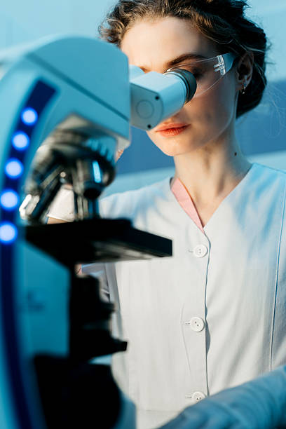 istock A young female scientist conducts research in a medical lab, using a microscope. 2203807169