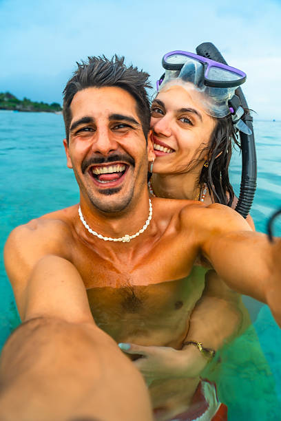 istock Happy couple taking a selfie while snorkeling in tropical water 2203808199