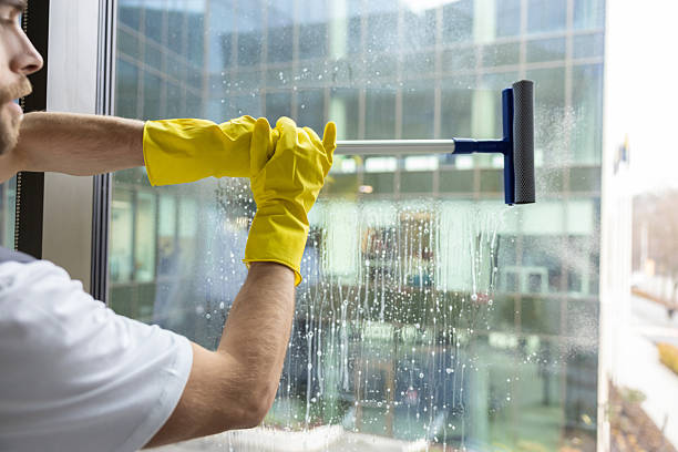 istock Cleaning person looking busy while cleaning the windows in the office 2203809257
