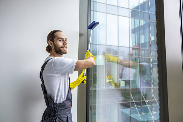 istock Young man cleaning the window with the window washer 2203809276