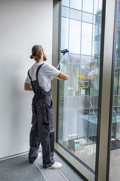 istock Young man cleaning the window with the window washer 2203809290