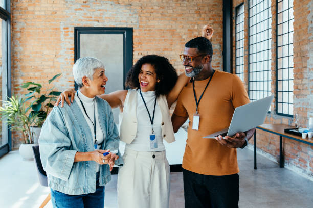 istock Smiling diverse colleagues enjoy a successful day in a bright workspace 2203810211