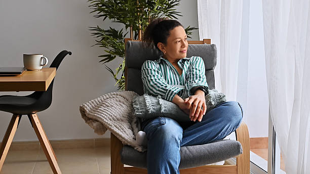 istock Woman Relaxing by a Bright Window 2203812465