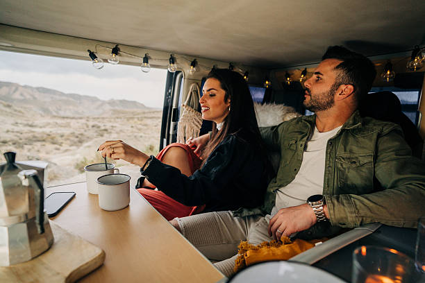 istock Couple enjoying coffee inside their camper van during road trip 2203815154
